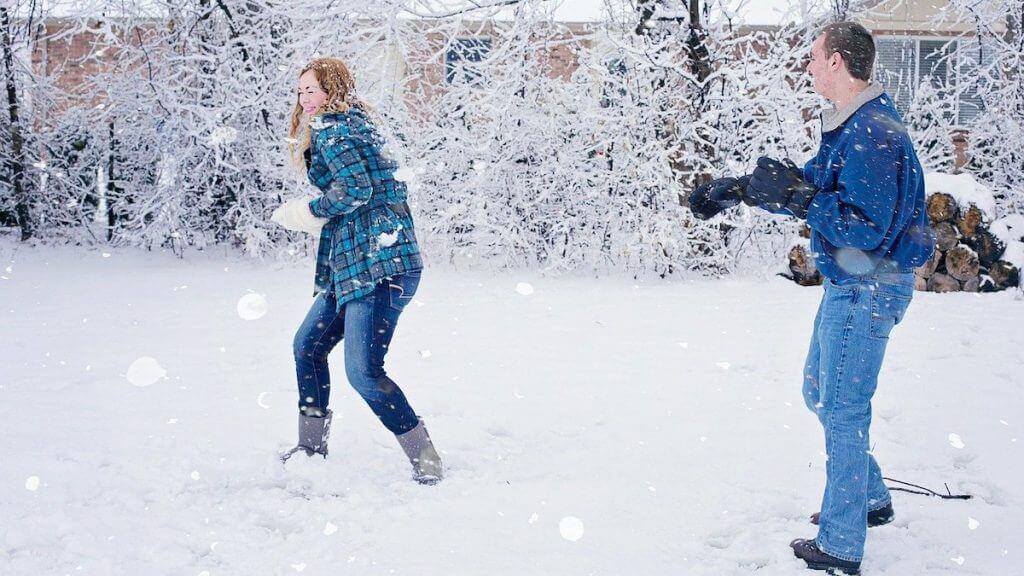 millennials in a snow ball fight after paying down debt