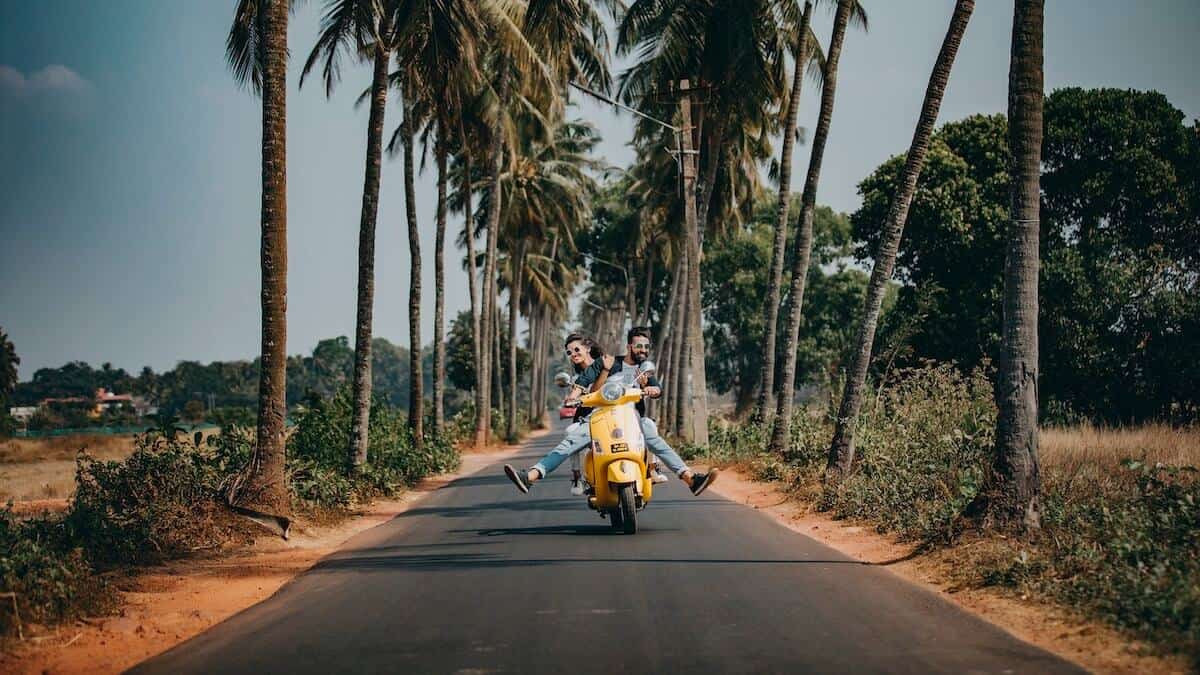 man and woman on a scooter traveling on a budget and not breaking the bank