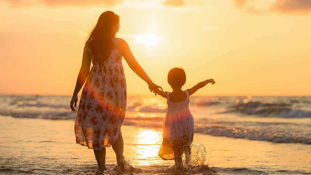 a woman on holiday with her daughter after investing her tax refund to build wealth