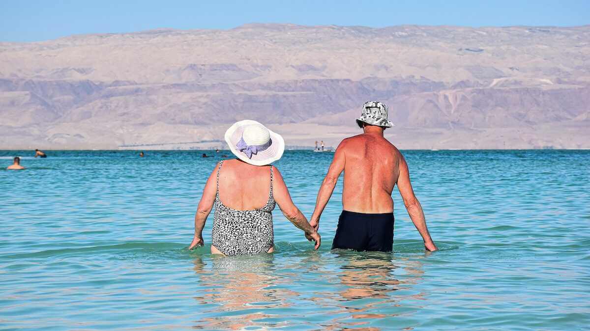 a retired couple at the beach thanks to their practical money skills