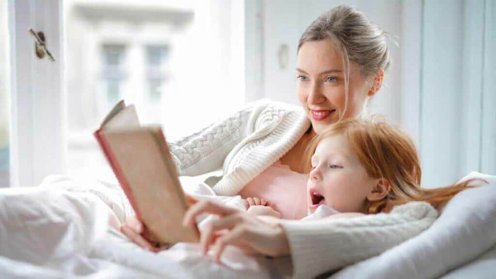 happy mother and daughter reading book