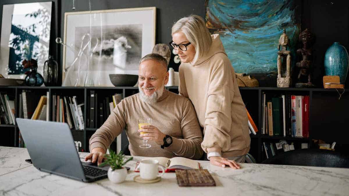 a retired senior citizen couple searching for travel discounts online
