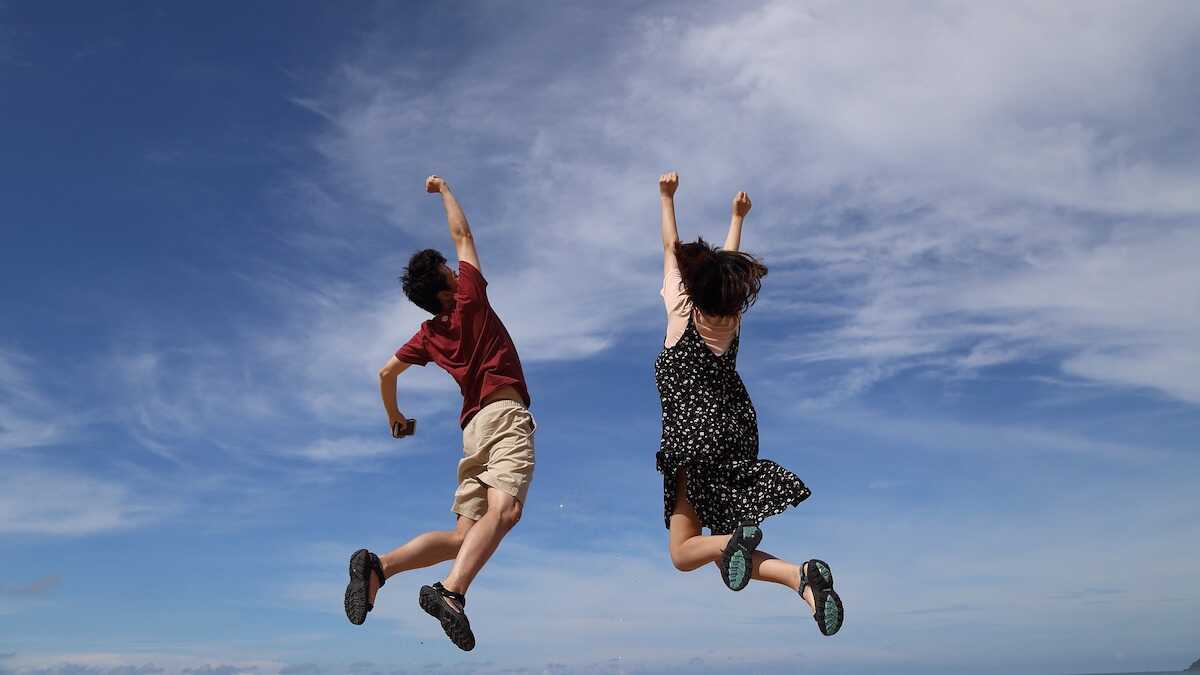 two young people celebrating by jumping