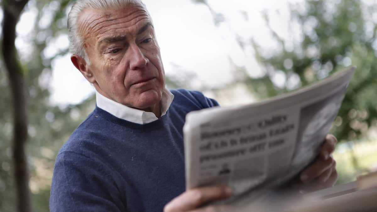 an old person reading the news paper