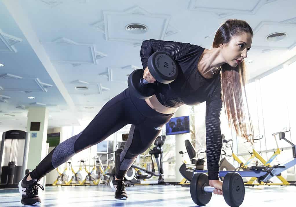 Woman Doing Exercise Inside Gym To become more productive and profitable